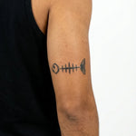 Tatuaggio semi-permanente INKON Minimalist Fish Skeleton applicato su un uomo – design 3 x 4 in (6x11cm), aspetto realistico dell'inchiostro, dura 10 giorni