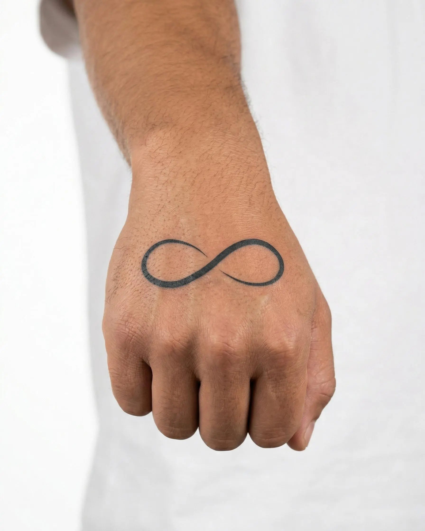 Tatuaggio semi-permanente INKON Infinity Symbol applicato su un uomo – design 2 x 2 in (5x5cm), aspetto realistico dell'inchiostro, dura 10 giorni