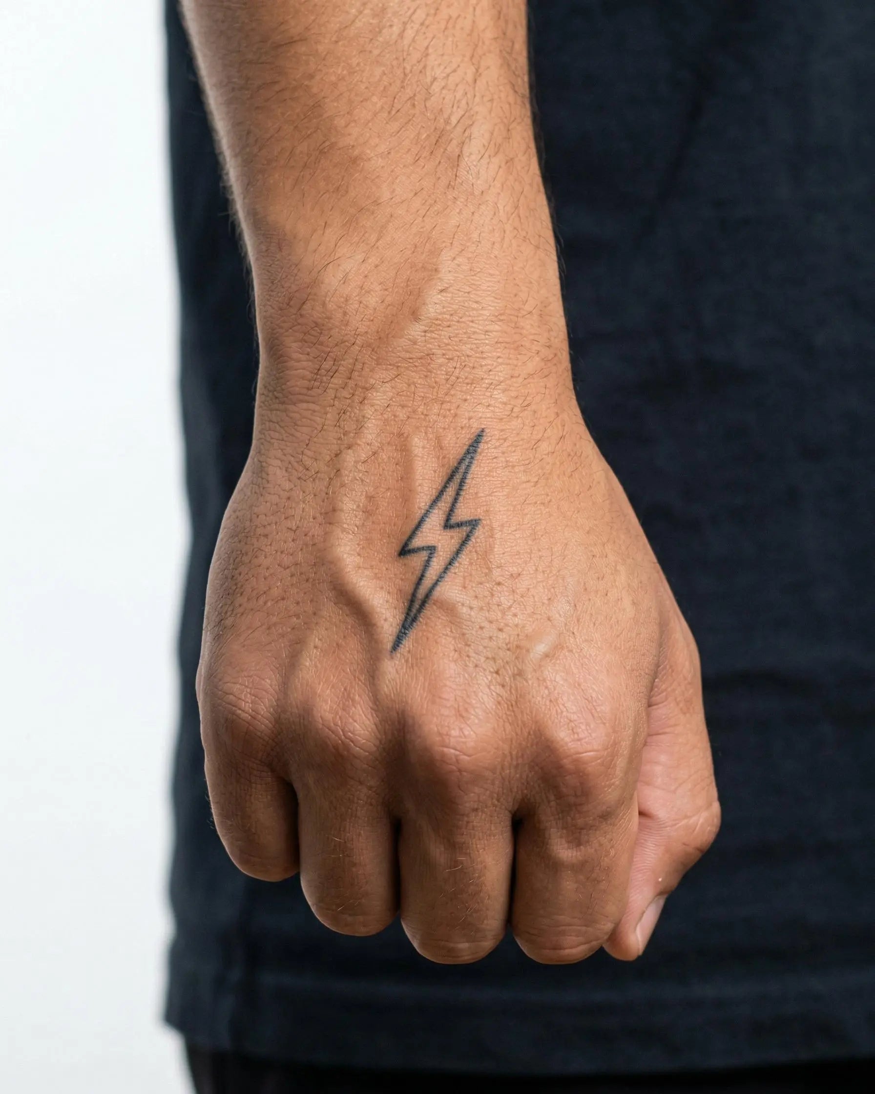 Tatuaggio semi-permanente INKON Thin Lightning Bolt applicato su un uomo – design 2 x 2 in (5x5cm), aspetto realistico dell'inchiostro, dura 10 giorni