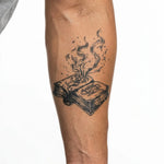 Tatuaggio semi-permanente INKON Burning Spell Book applicato su un uomo – design 4 x 4 in (9x9cm), aspetto realistico dell'inchiostro, dura 10 giorni