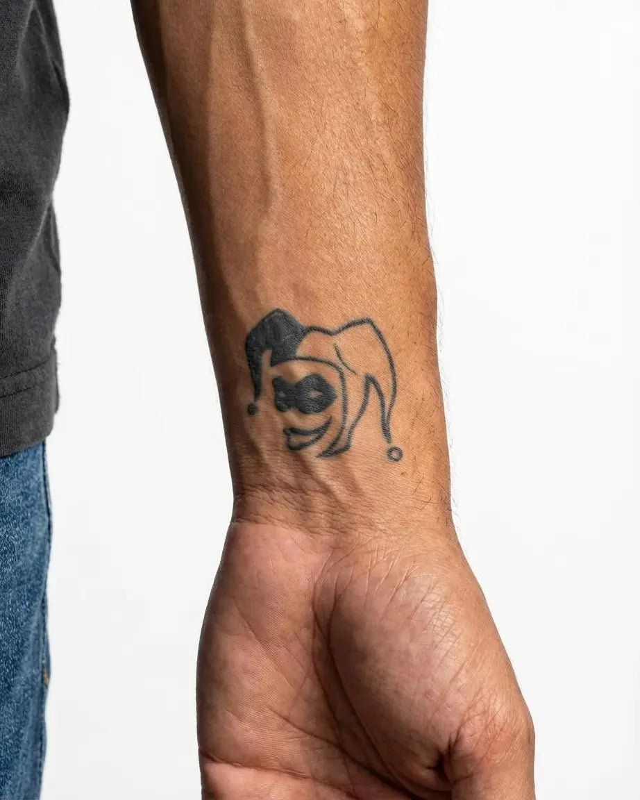 Tatuaggio semi-permanente INKON Jester Face applicato su un uomo – design 2 x 2 in (5x5cm), aspetto realistico dell'inchiostro, dura 10 giorni