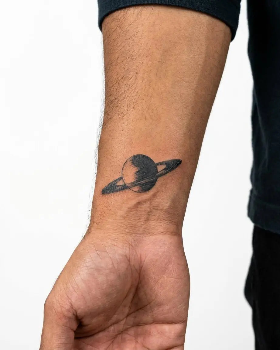 Tatuaggio semi-permanente INKON Saturn Planet applicato su un uomo – design 2 x 2 in (5x5cm), aspetto realistico dell'inchiostro, dura 10 giorni