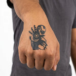 Tatuaggio semi-permanente INKON Armored Hero applicato su un uomo – design 2 x 2 in (5x5cm), aspetto realistico dell'inchiostro, dura 10 giorni