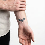 Tatuaggio semi-permanente INKON Bat Silhouette applicato su un uomo – design 2 x 2 in (5x5cm), aspetto realistico dell'inchiostro, dura 10 giorni