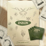 Kit di confezionamento completo INKON Tattoos For Now su superficie di marmo – busta verde brandizzata con illustrazioni floreali e di farfalle, salvietta primer idratante per la pelle, scheda con le istruzioni di applicazione con QR code e adesivo brandizzato INKON Tattoo